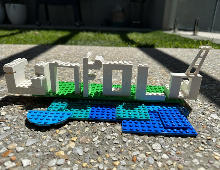 UNFOLD in Lego — white letterforms on blue/green base
